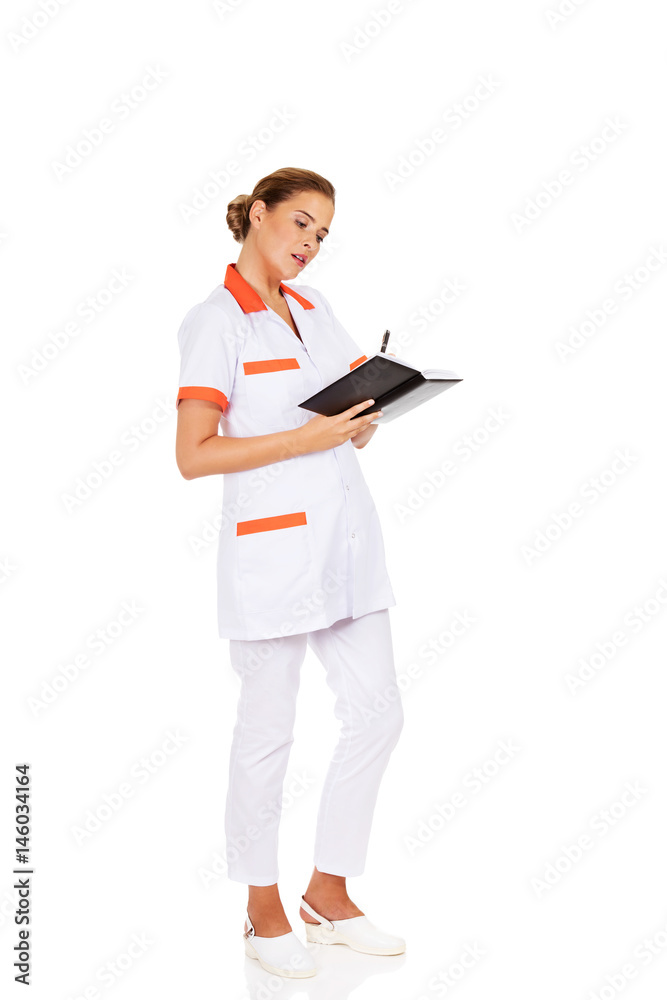 Young focus female doctor or nurse makes notes Young focus female doctor or nurse makes notes
