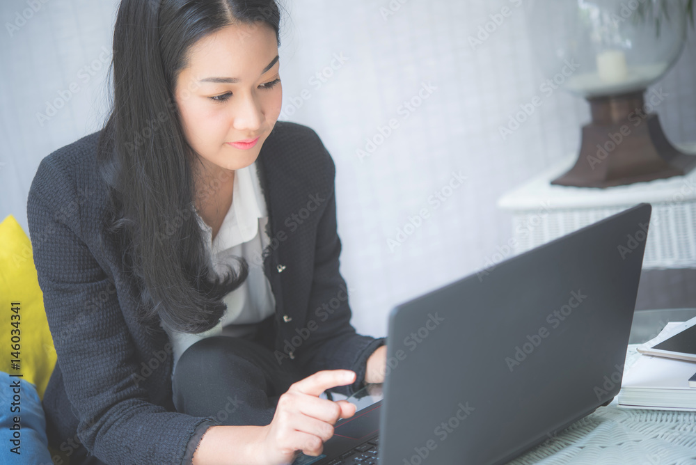 Business woman working with laptop in living room Business woman working with laptop in living room