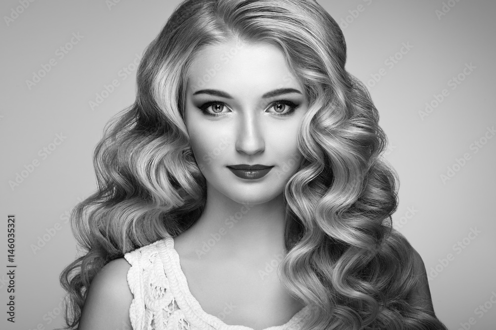 Beautiful girl with long wavy and shiny hair . Blonde woman with curly hairstyle. Perfect make-up. Fashion photo. Black and White photo