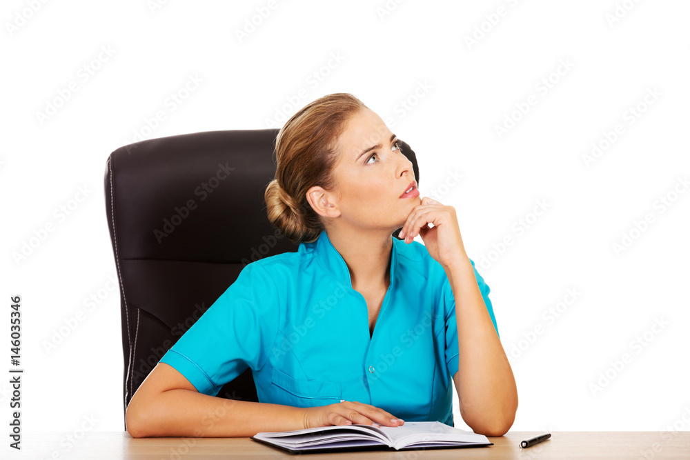 Doctor sitting behind the desk and thinking about something Doctor sitting behind the desk and thinking about something