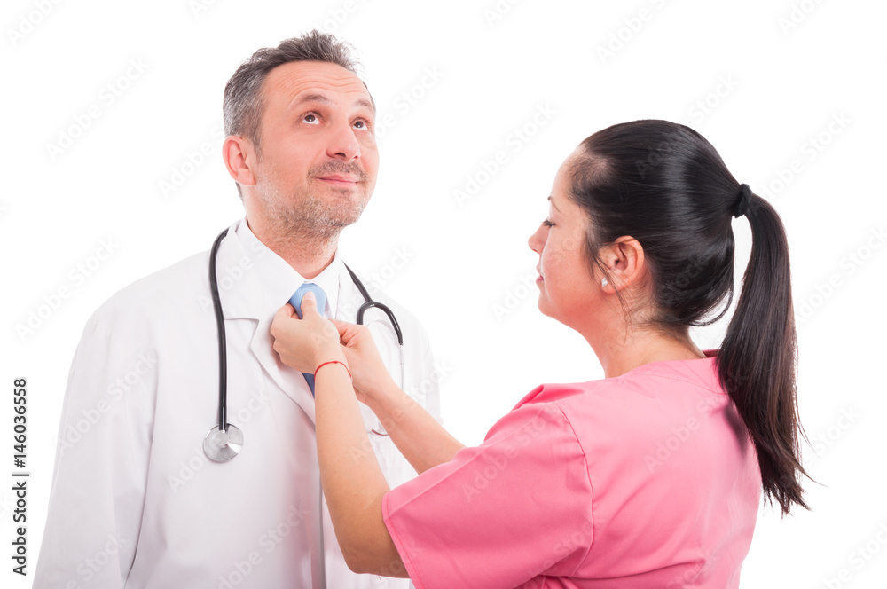 Young nurse adjusting tie of handsome medic Young nurse adjusting tie of handsome medic