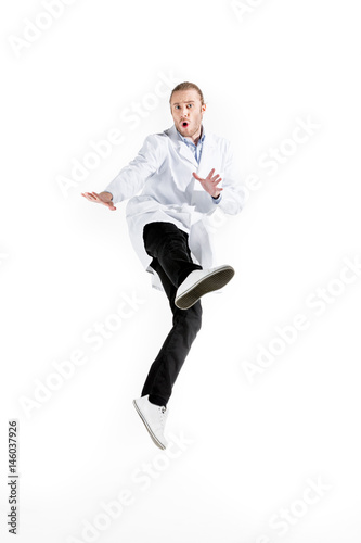 young doctor in white coat jumping isolated on white