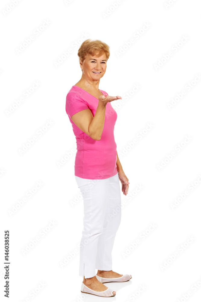An old smiling woman presenting something An old smiling woman presenting something