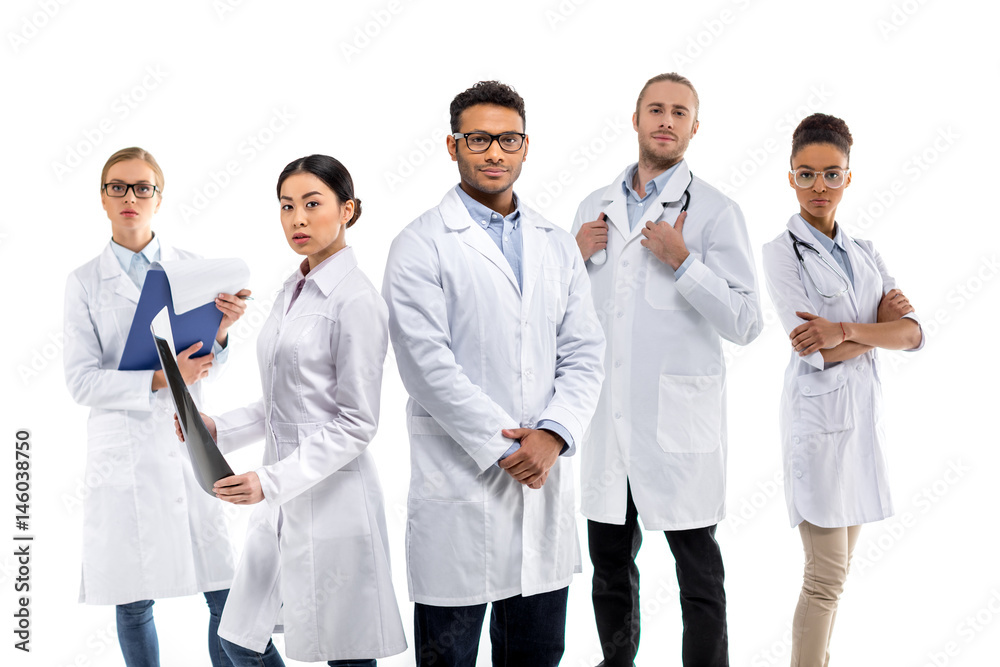 Group of young confident professional doctors standing together isolated on white Group of young confident professional doctors standing together isolated on white