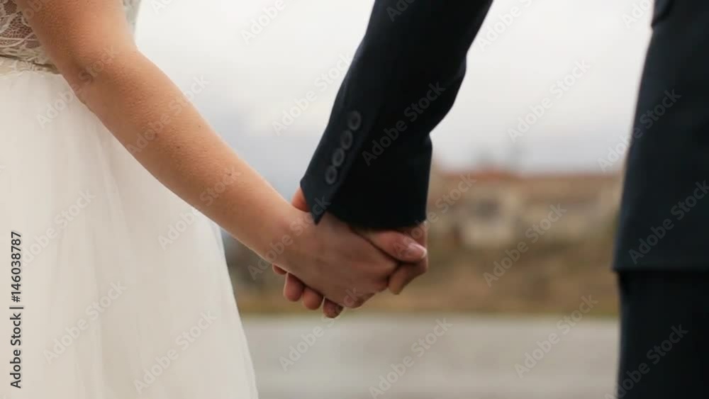 Wedding couple holding hands on olod castle with lake background. slow motion Wedding couple holding hands on olod castle with lake background. slow motion