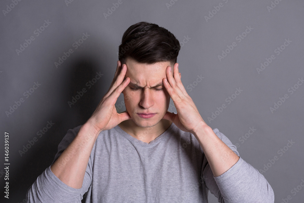 Concentrated pensive man holding fingers on temple Concentrated pensive man holding fingers on temple