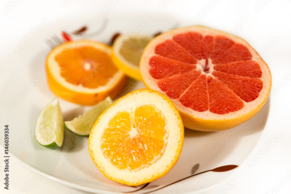 Fresh Lemon, Lime, Grapefruit And Orange Fruits on Top of White Porcelain Plate Fresh Lemon, Lime, Grapefruit And Orange Fruits on Top of White Porcelain Plate