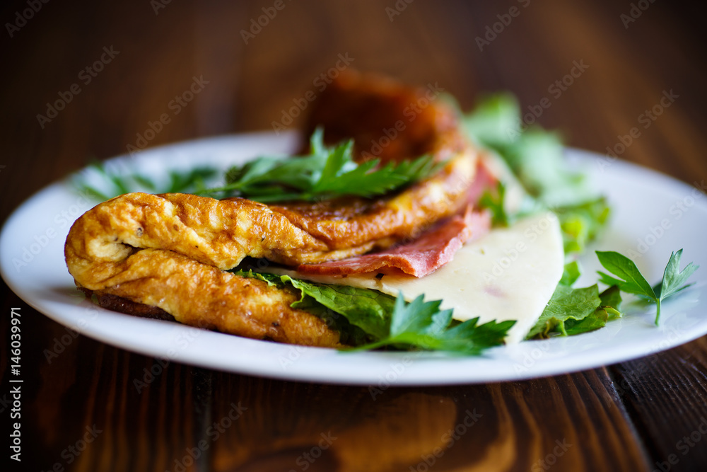 Hot stuffed omelette with cheese, sausage and lettuce leaves Hot stuffed omelette with cheese, sausage and lettuce leaves