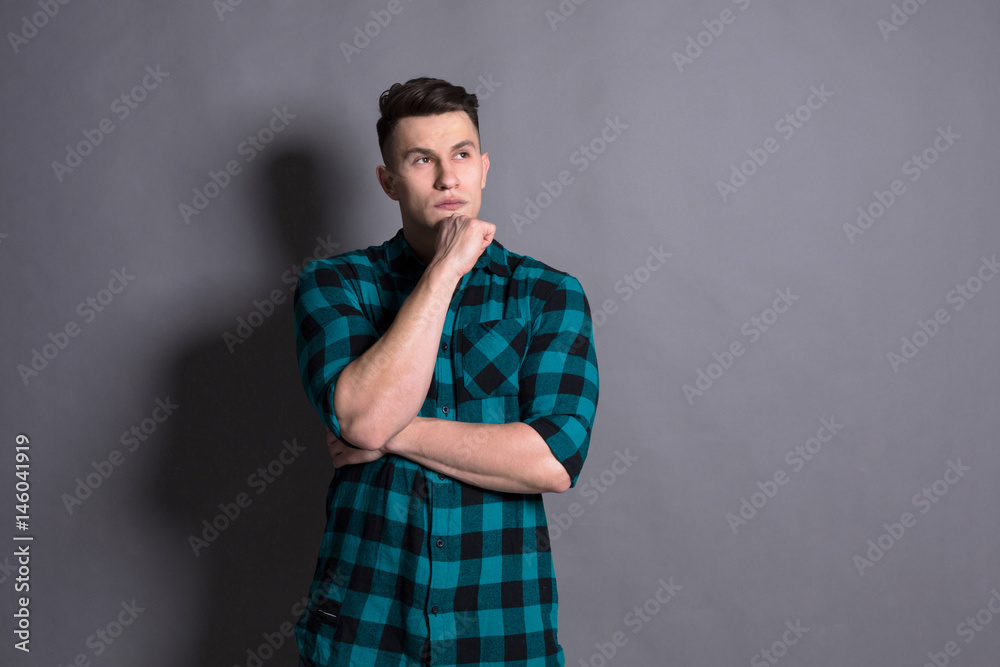 Pensive young man portrait at studio background. Pensive young man portrait at studio background.