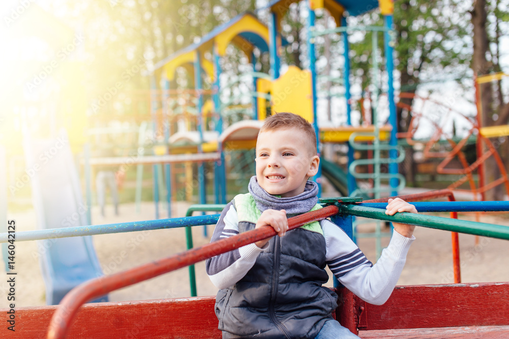 Little boy play on playground with blur park background Little boy play on playground with blur park background