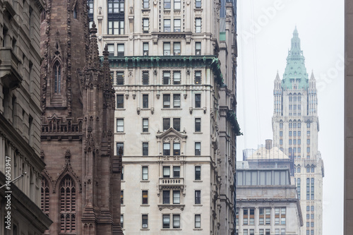 New York City, Lower Manhattan, arhitectural detail of Broadway street wiev: Trinity Church, New York City Charter School Center and Woolworth building far away. photo