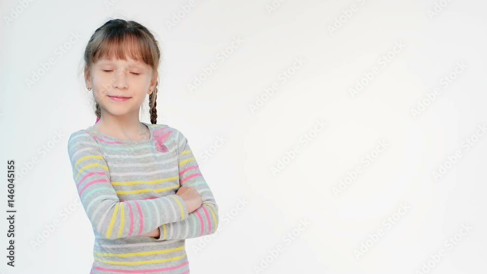 Calm little girl standing with folded hands looking at camera, locked down real time video Calm little girl standing with folded hands looking at camera, locked down real time video