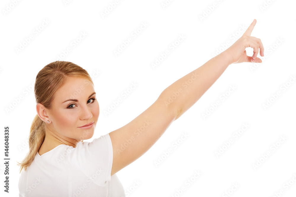 Young woman pointing on copy space or something Young woman pointing on copy space or something