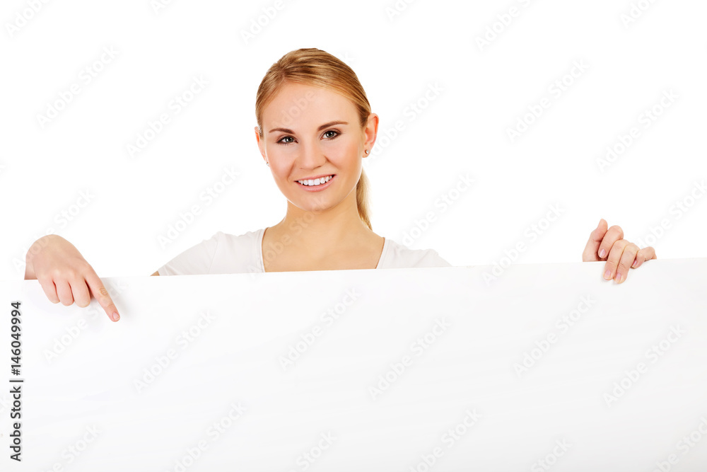 Smiling young woman pointing for empty banner Smiling young woman pointing for empty banner