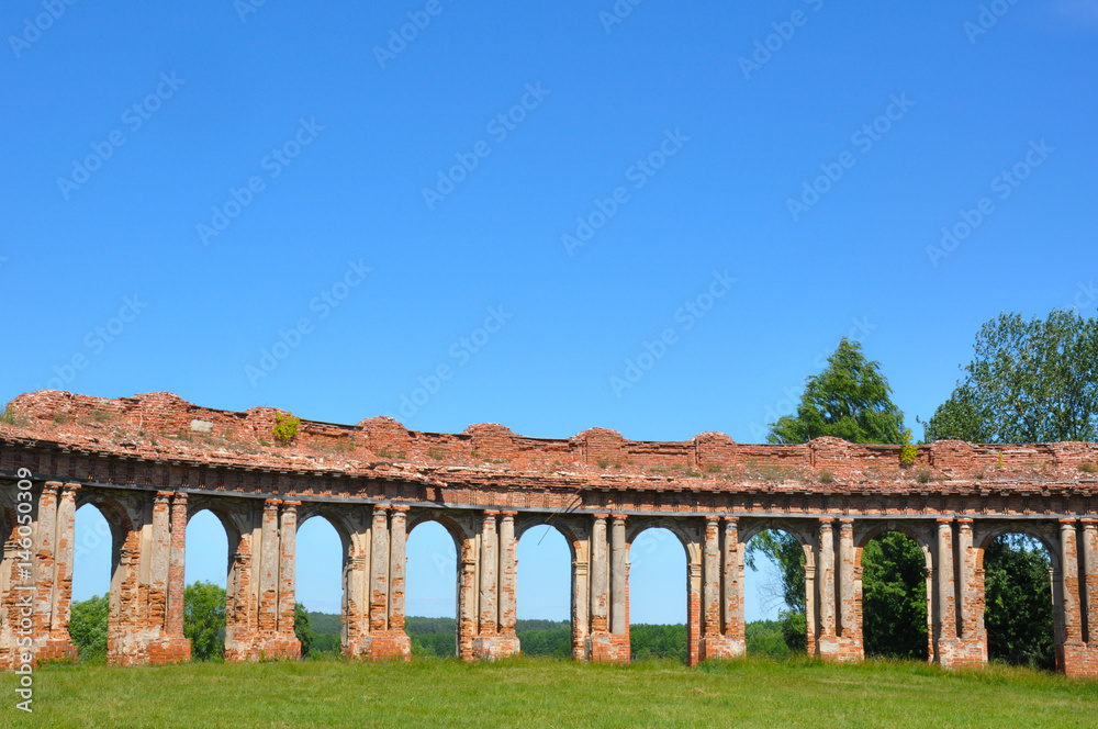 Obraz premium Structured bricks colonnades with blue sky summer background