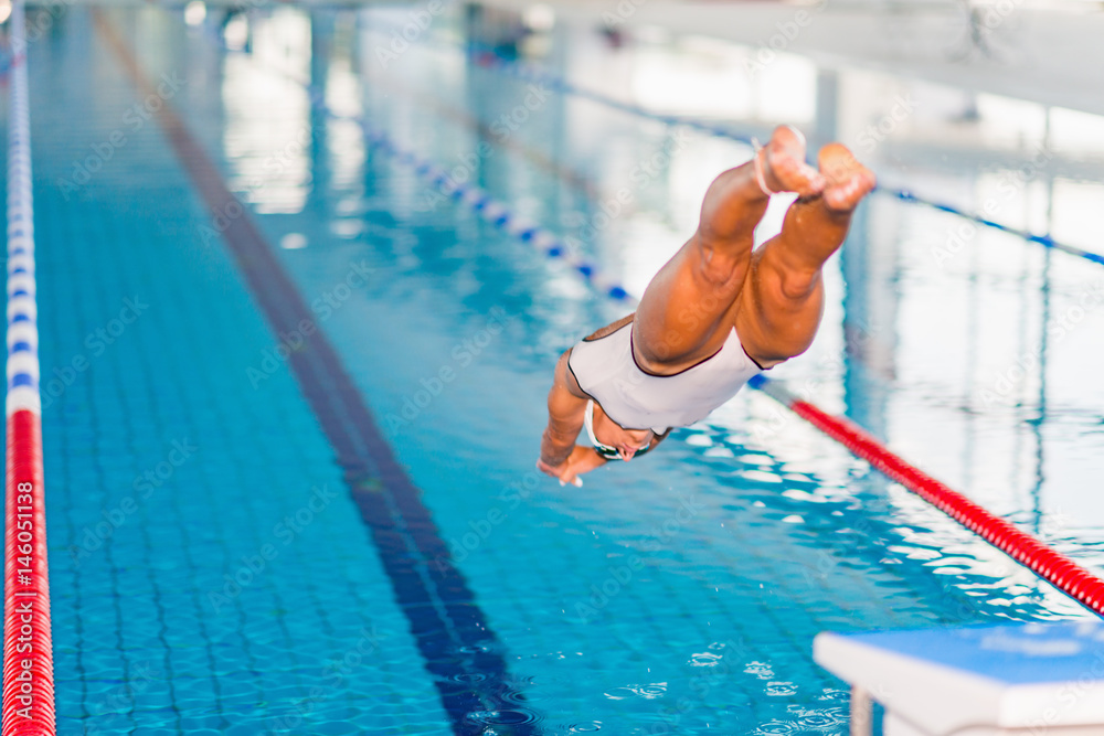 Female swimmer jumping in to the pool