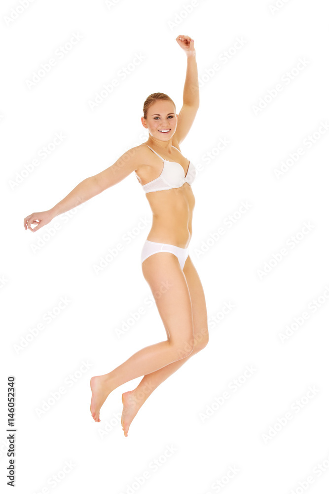Happy young woman in white underwear jumping