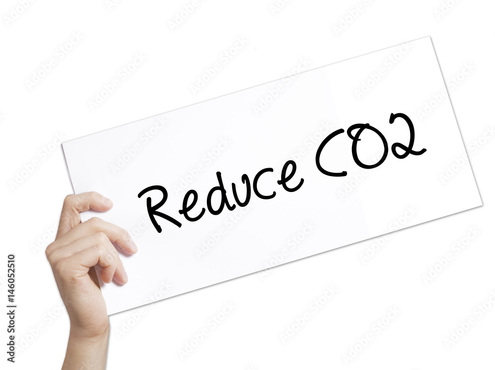 Reduce CO2 Sign on white paper. Man Hand Holding Paper with text. Isolated on white background. Reduce CO2 Sign on white paper. Man Hand Holding Paper with text. Isolated on white background.
