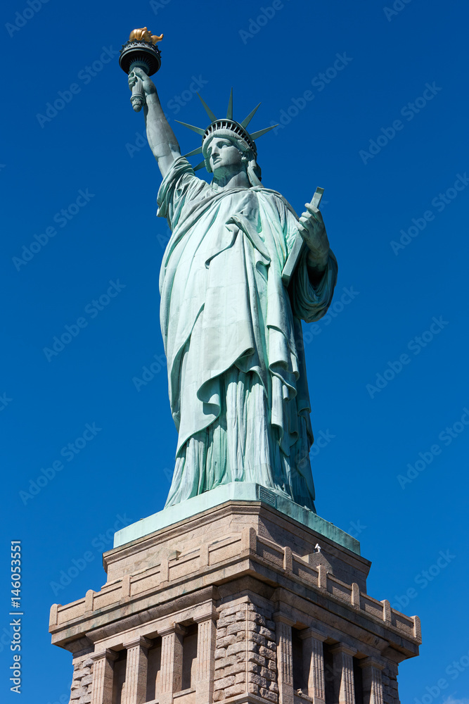 Statue of Liberty and pedestal on clear dark blue sky in a sunny day