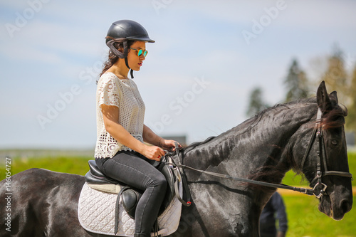 Lovely young brunette with sunglasses, riding a horse © seba tataru