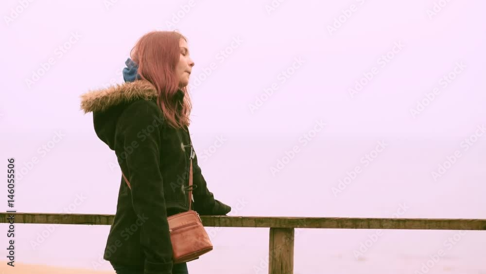 Young girl enjoys rain in a spring forest near sea. Closeup 60 to 24fps 4K UHD