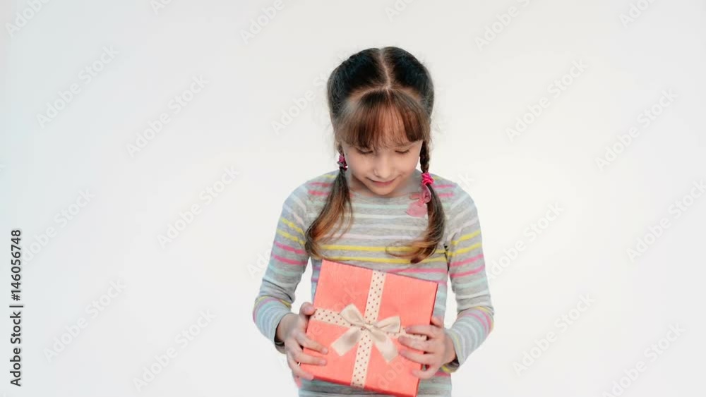 Little girl opening her gift feeling surprised embracing a box with happiness, locked down real time video Little girl opening her gift feeling surprised embracing a box with happiness, locked down real time video