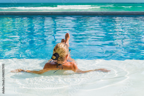 Relaxing woman in luxury hotel pool on holidays vacation