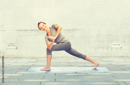 Fototapeta Naklejka Na Ścianę i Meble -  woman making yoga low angle lunge pose on mat