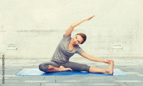 happy woman making yoga and stretching on mat