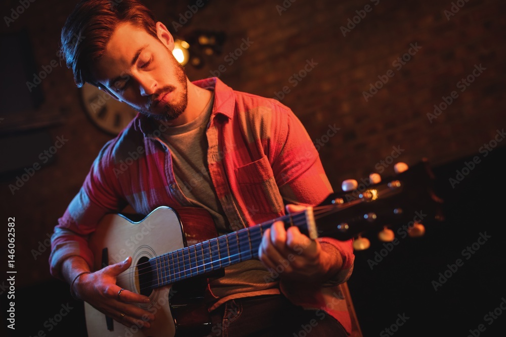 Fototapeta premium Young man playing guitar 
