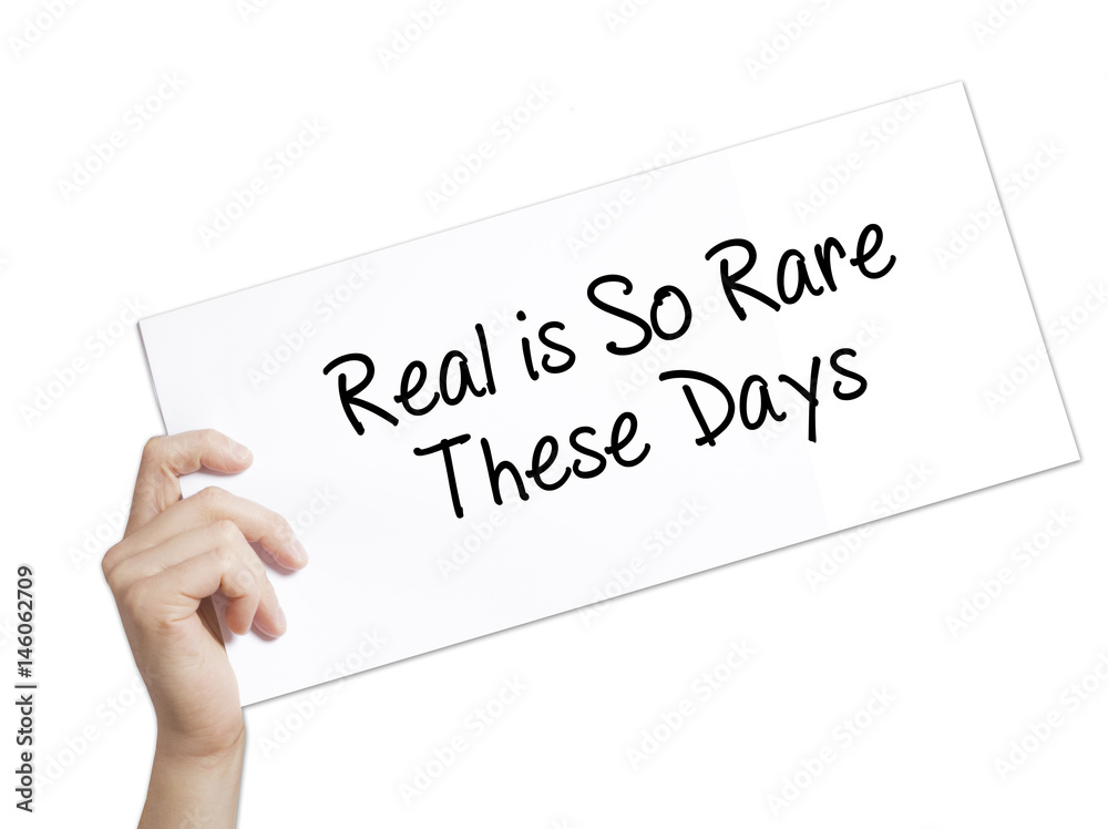 Real is So Rare These Days Sign on white paper. Man Hand Holding Paper with text. Isolated on white background. Real is So Rare These Days Sign on white paper. Man Hand Holding Paper with text. Isolated on white background.