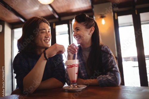 Happy couple having milkshake