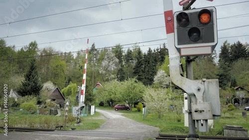 Railroad crossing with railway gate that close. Level crossing occurs where railway barrier line is intersected by road or path on one level. Type of at-grade intersection. Static day stabilized shot.