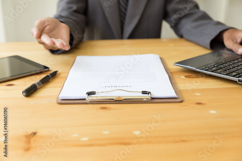 businessman with a contract giving a hand - presenting & signing business document