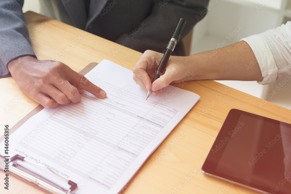 Person's hand hold ballpoint pen writing on blank application form paper sheet, fill in empty document template, applying for auto insurance Person's hand hold ballpoint pen writing on blank application form paper sheet, fill in empty document template, applying for auto insurance