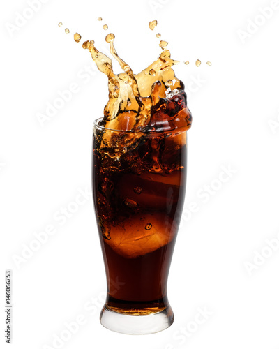 Brown soft drink splashing out of a glass isolated on white background.