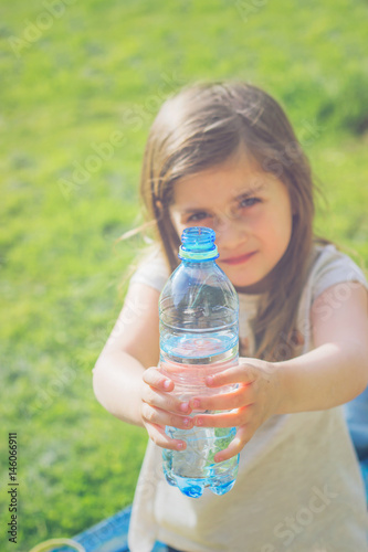 Little girl holds bottle of water