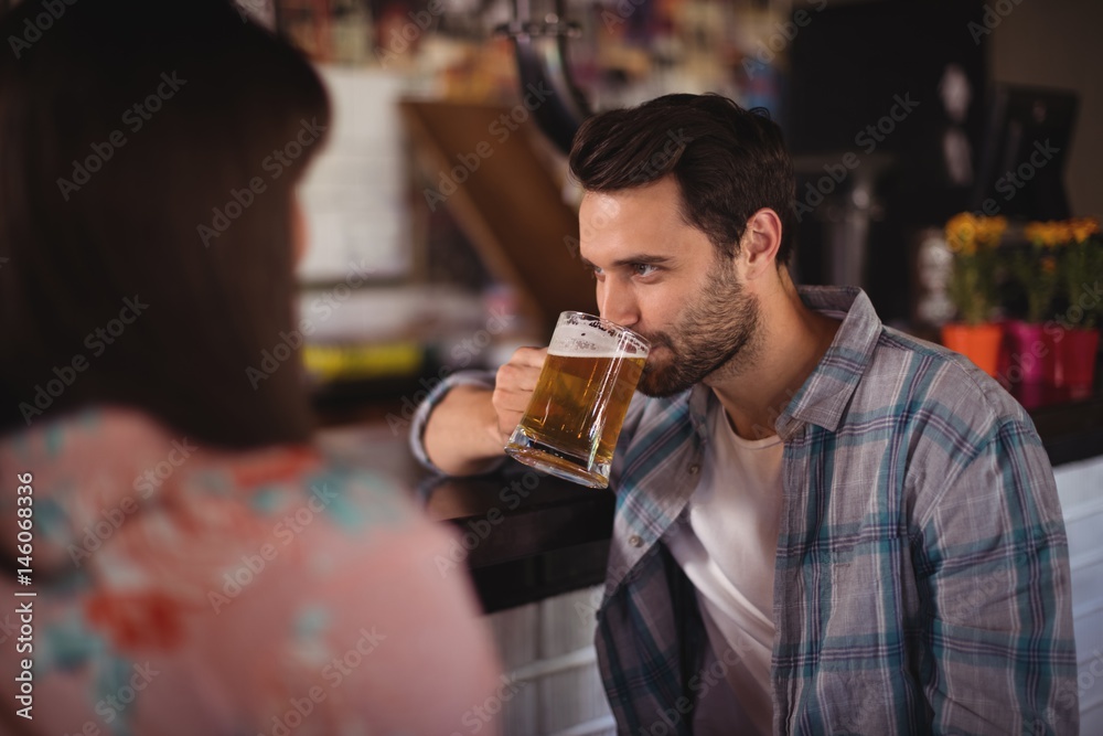 Couple having beer at counter Couple having beer at counter