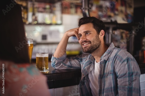 Happy couple interacting while having beer at counter © WavebreakMediaMicro