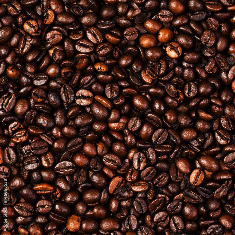 Naklejka premium Coffee beans background macro. Dark Roasted coffee beans textured wallpaper for your design with copy space.