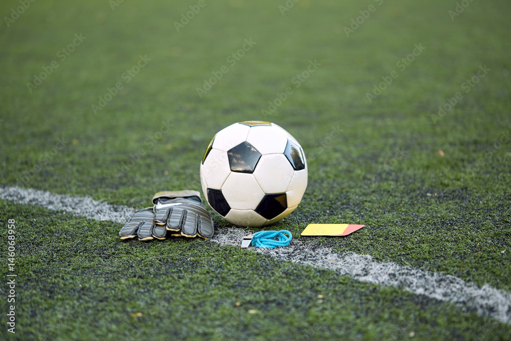 Fototapeta premium ball, gloves, whistle and cards on soccer field