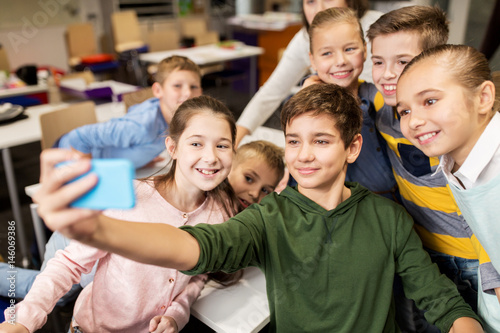group of school kids taking selfie with smartphone