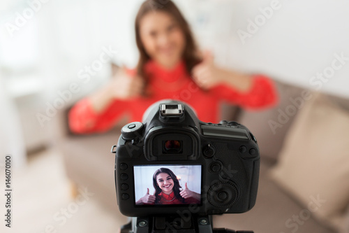 woman with camera recording video at home