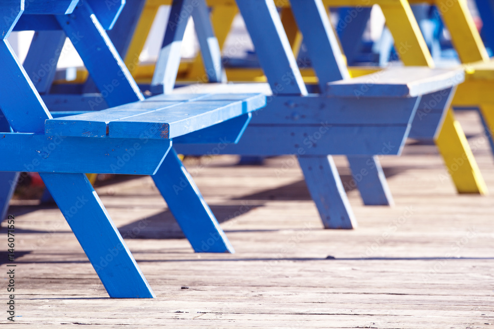 Detail view of picnic table seats in bright sunshine Detail view of picnic table seats in bright sunshine