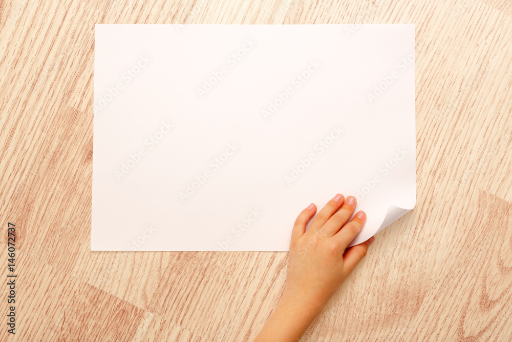 Fototapeta premium Child's hand turning over paper