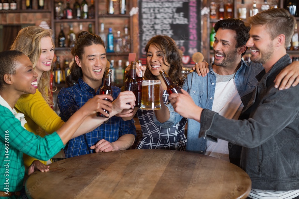 Cheerful friends toasting beer glasses and bottles Cheerful friends toasting beer glasses and bottles