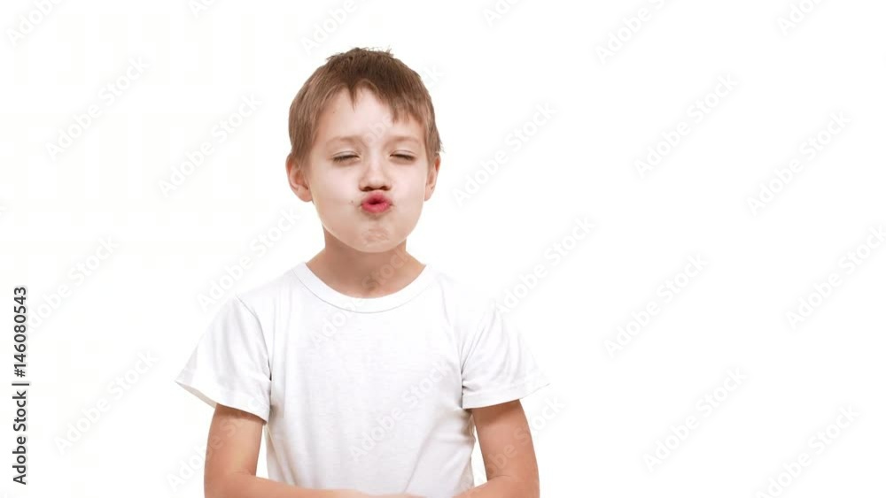 Elementary-school aged Caucasian boy making faces and kidding around standing on white background Elementary-school aged Caucasian boy making faces and kidding around standing on white background