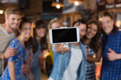 Group of friends taking selfie through mobile phone