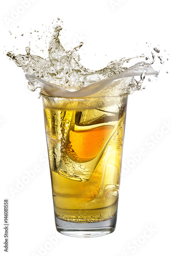 A shot glass filled with alcohol, placed inside a glass with beer. Splash