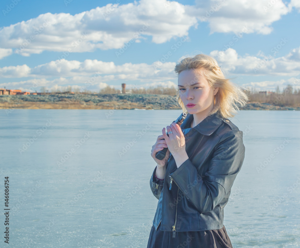 Fototapeta premium girl with a gun and a black jacket.